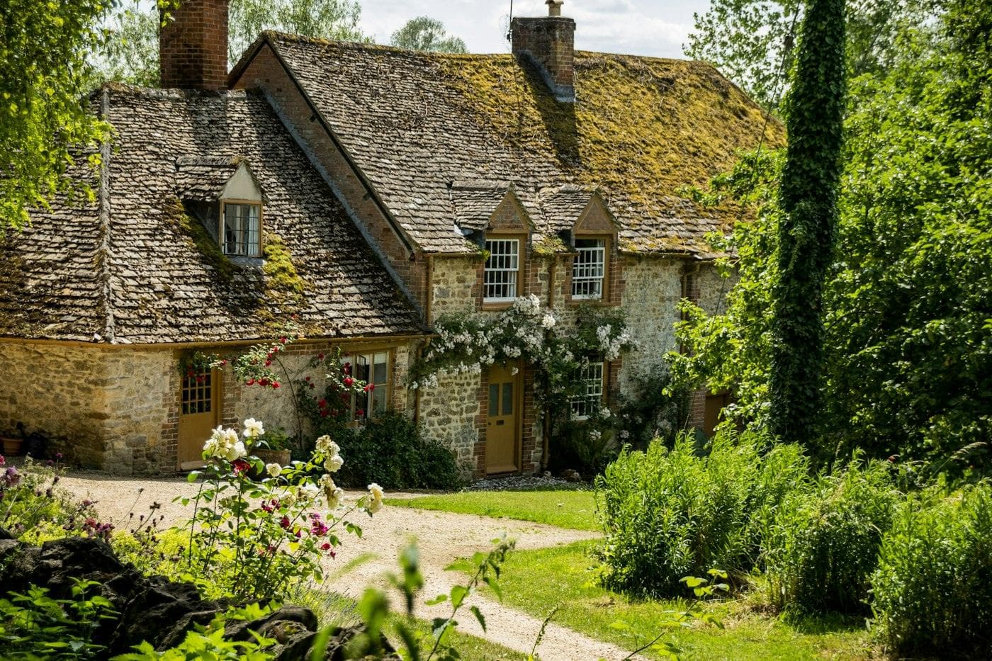 A stone cottage with a flowering front garden